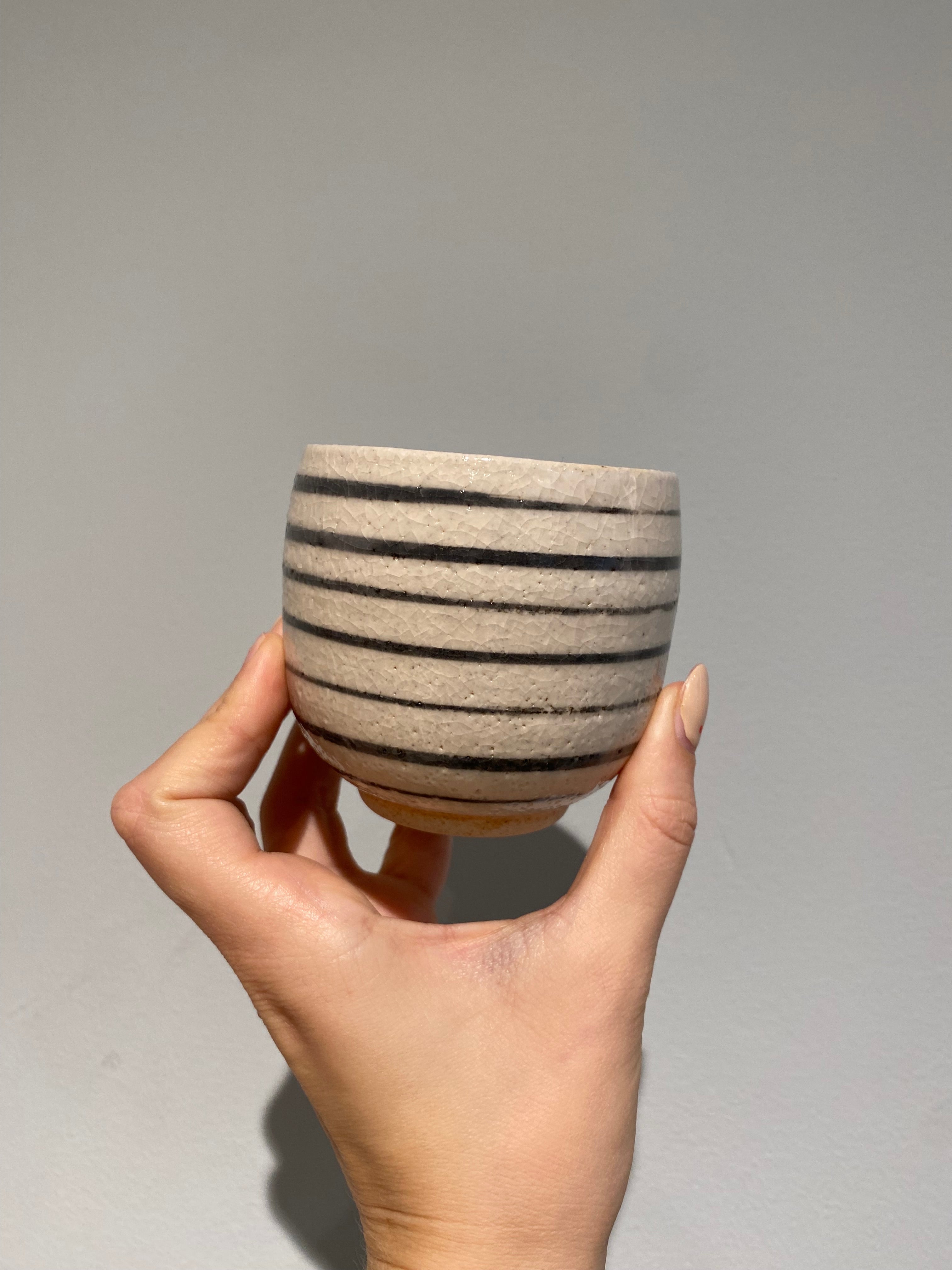 Small white cup with black stripes