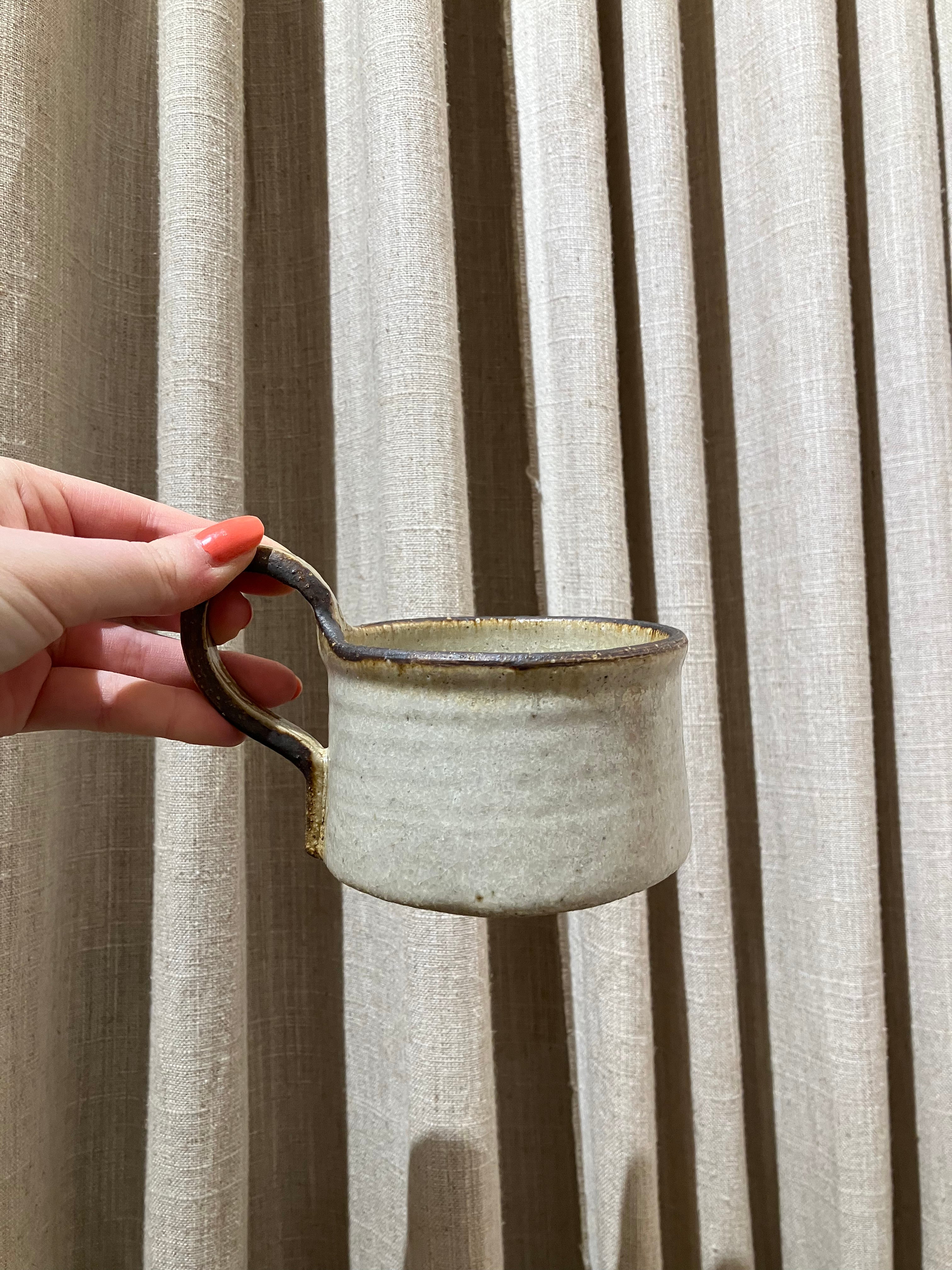 Rustic cup with brown rim and handle