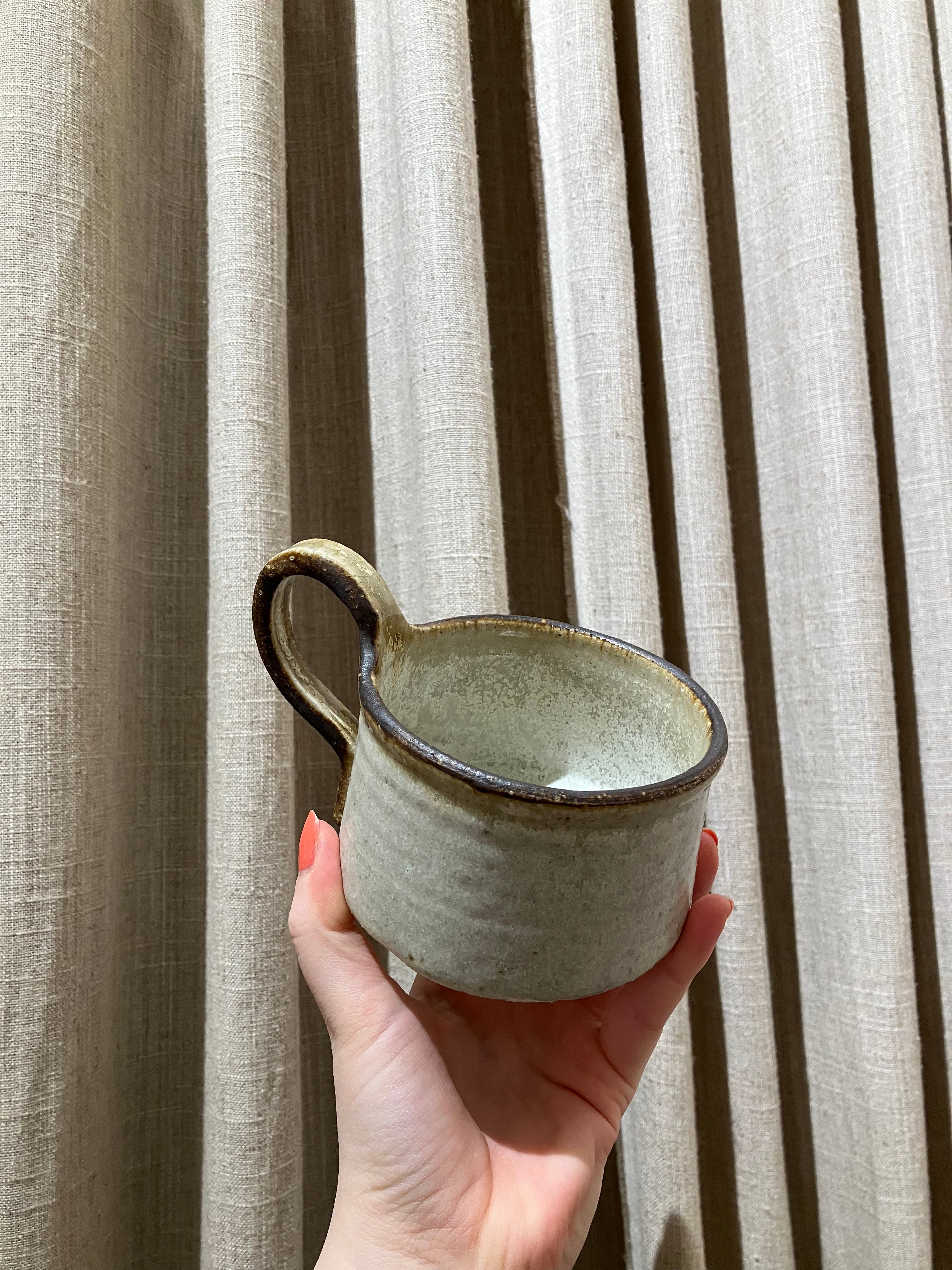 Rustic cup with brown rim and handle