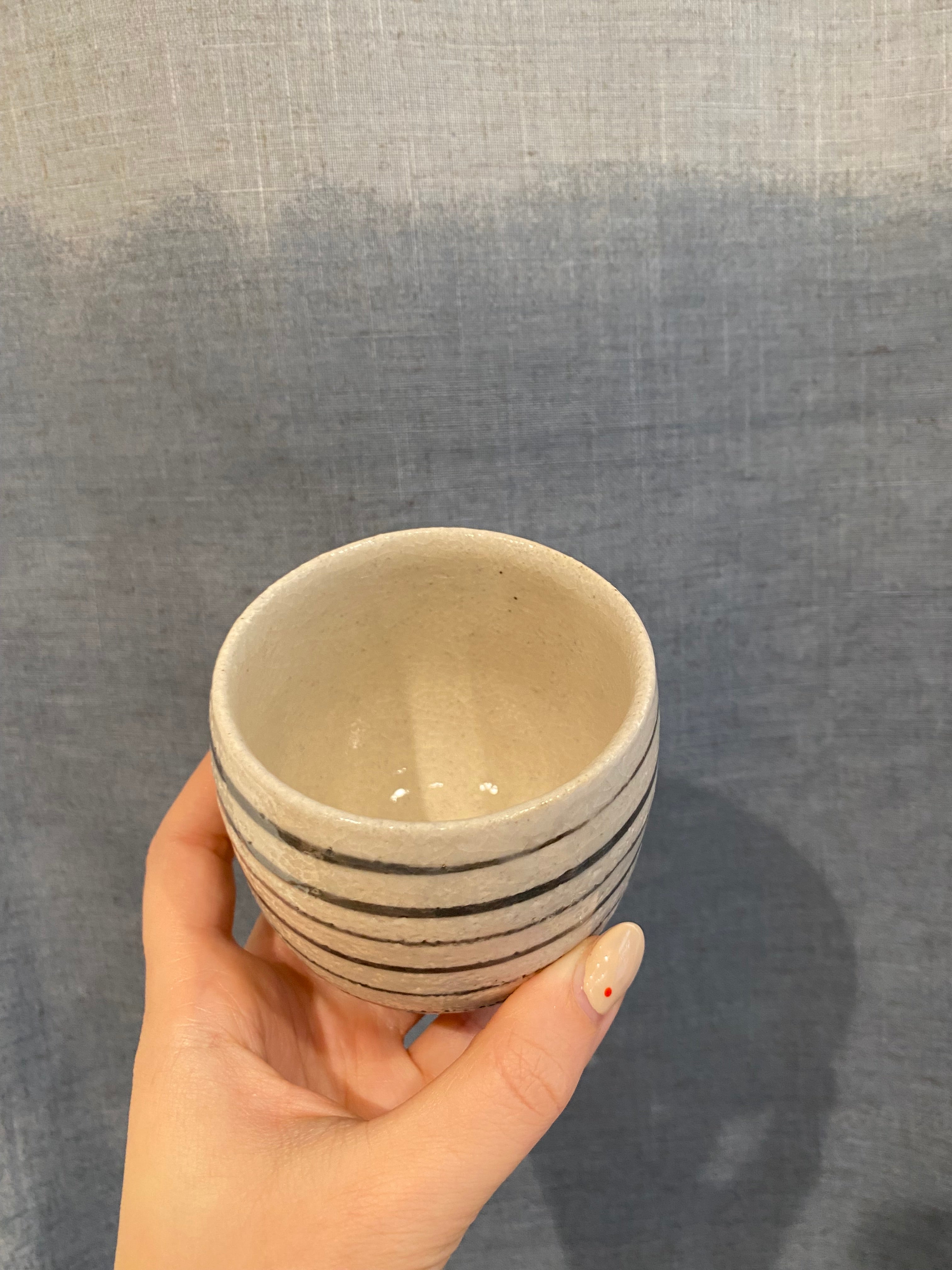 Small white cup with black stripes