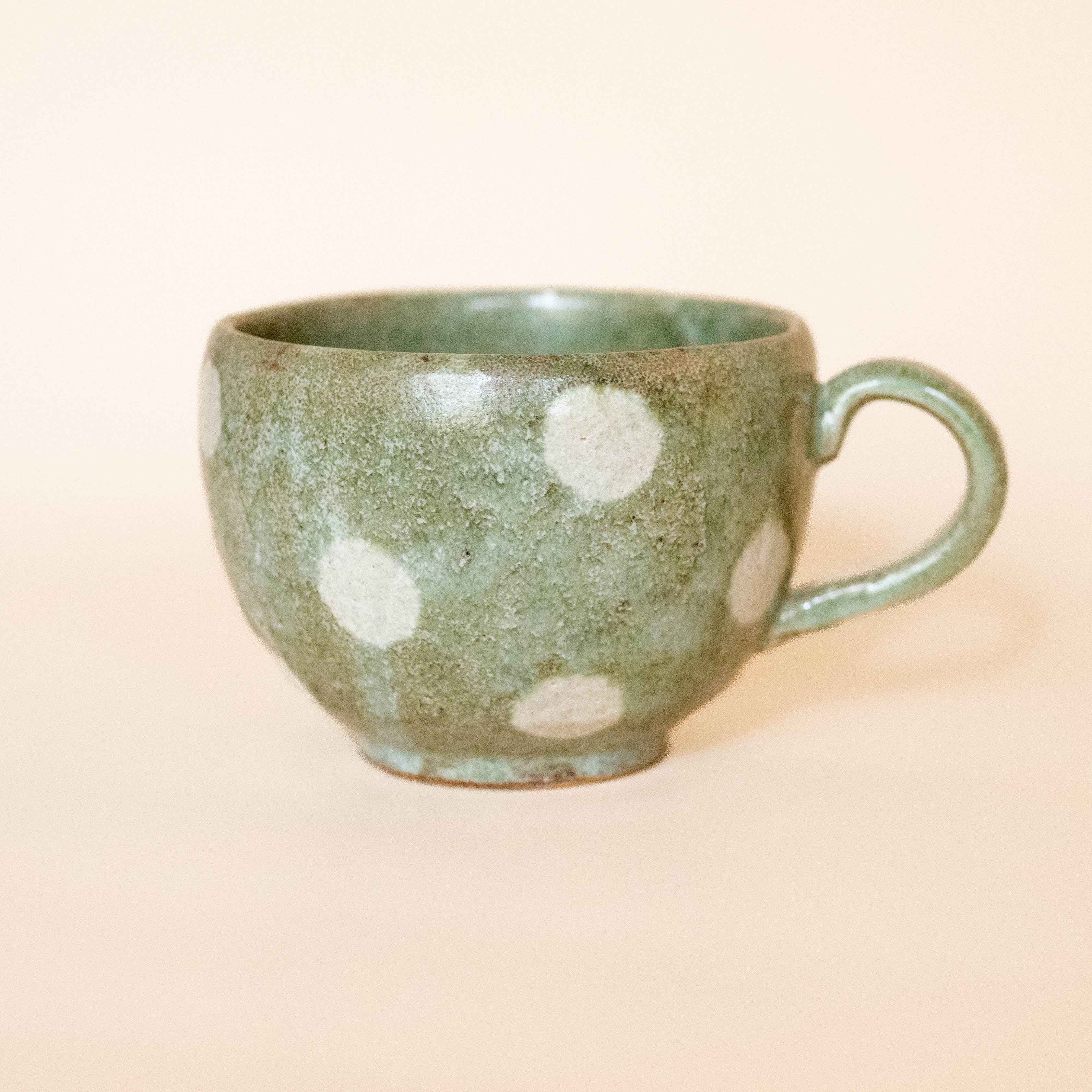 Japanese ceramic cup with green glaze and white dots