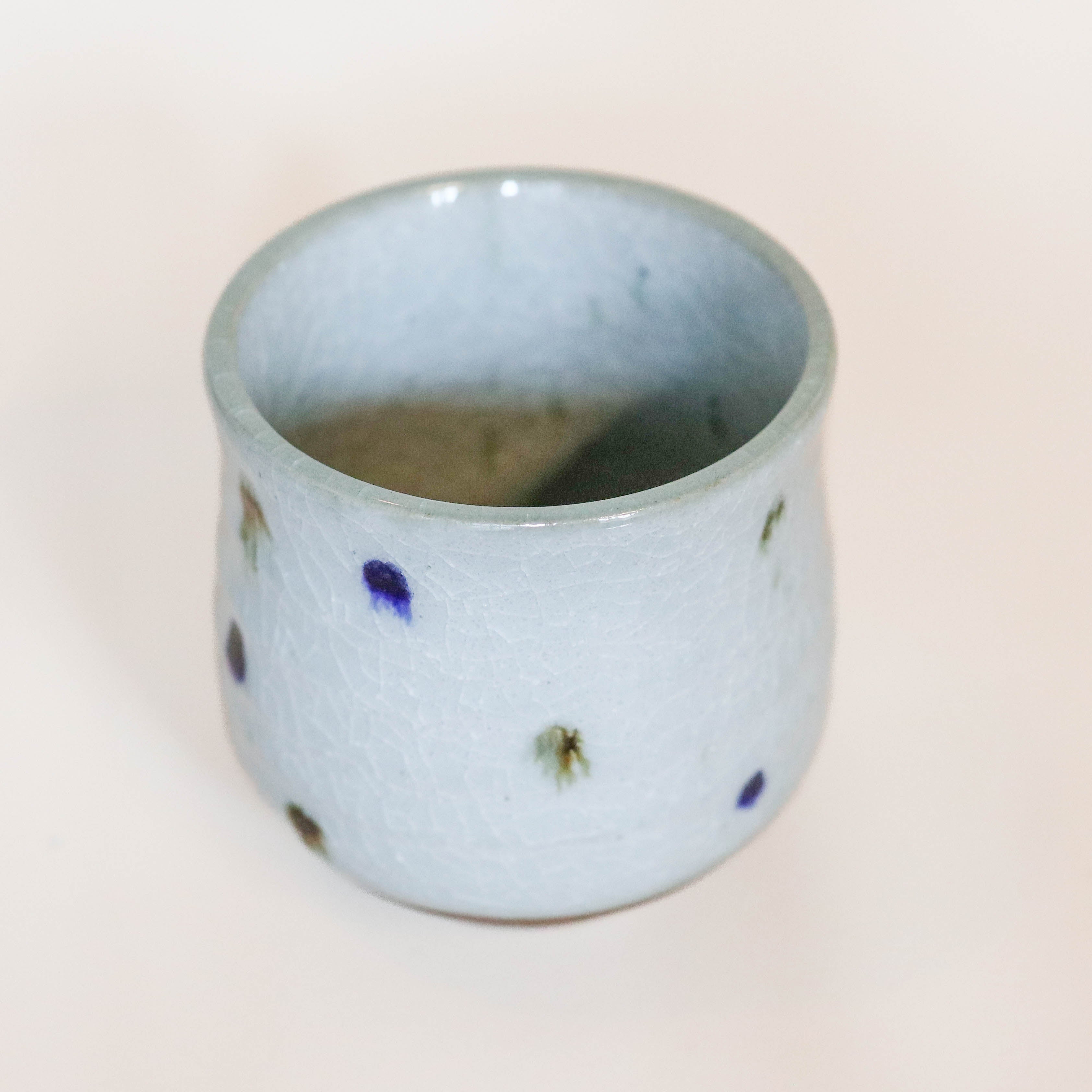 Gray cup with blue and brown dots