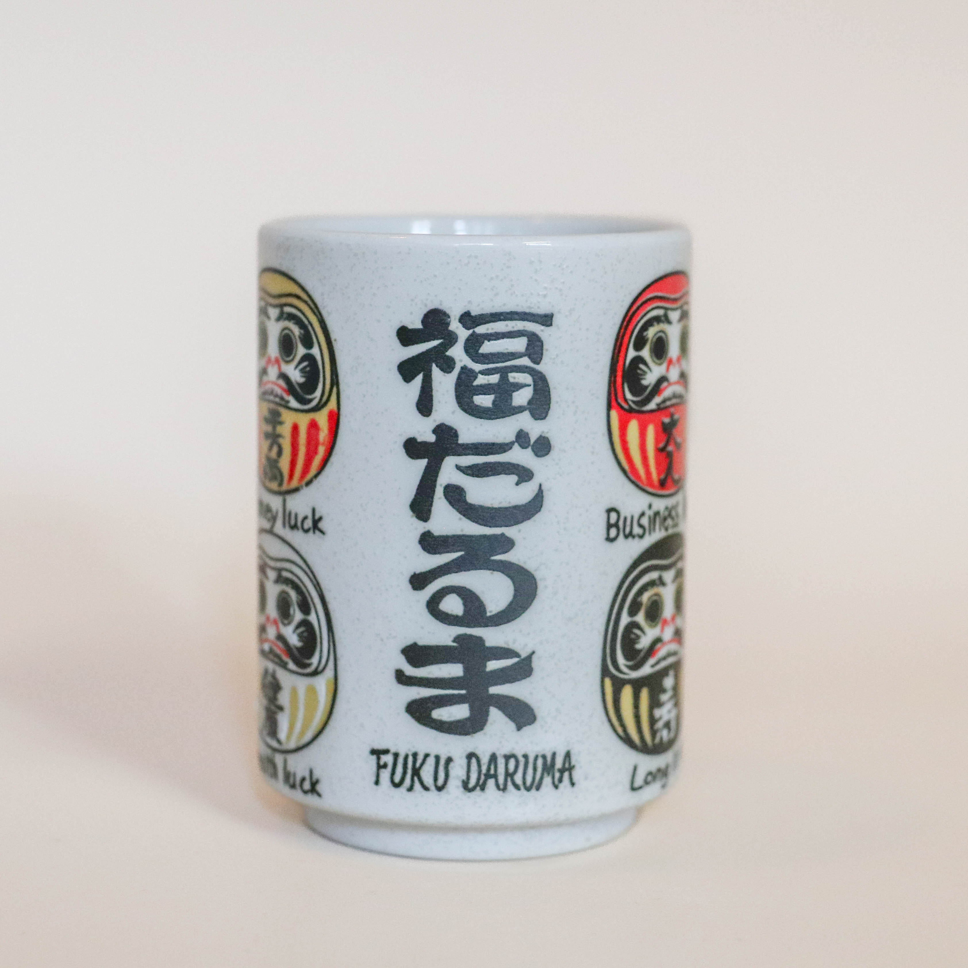 Cup with large Daruma in different colors